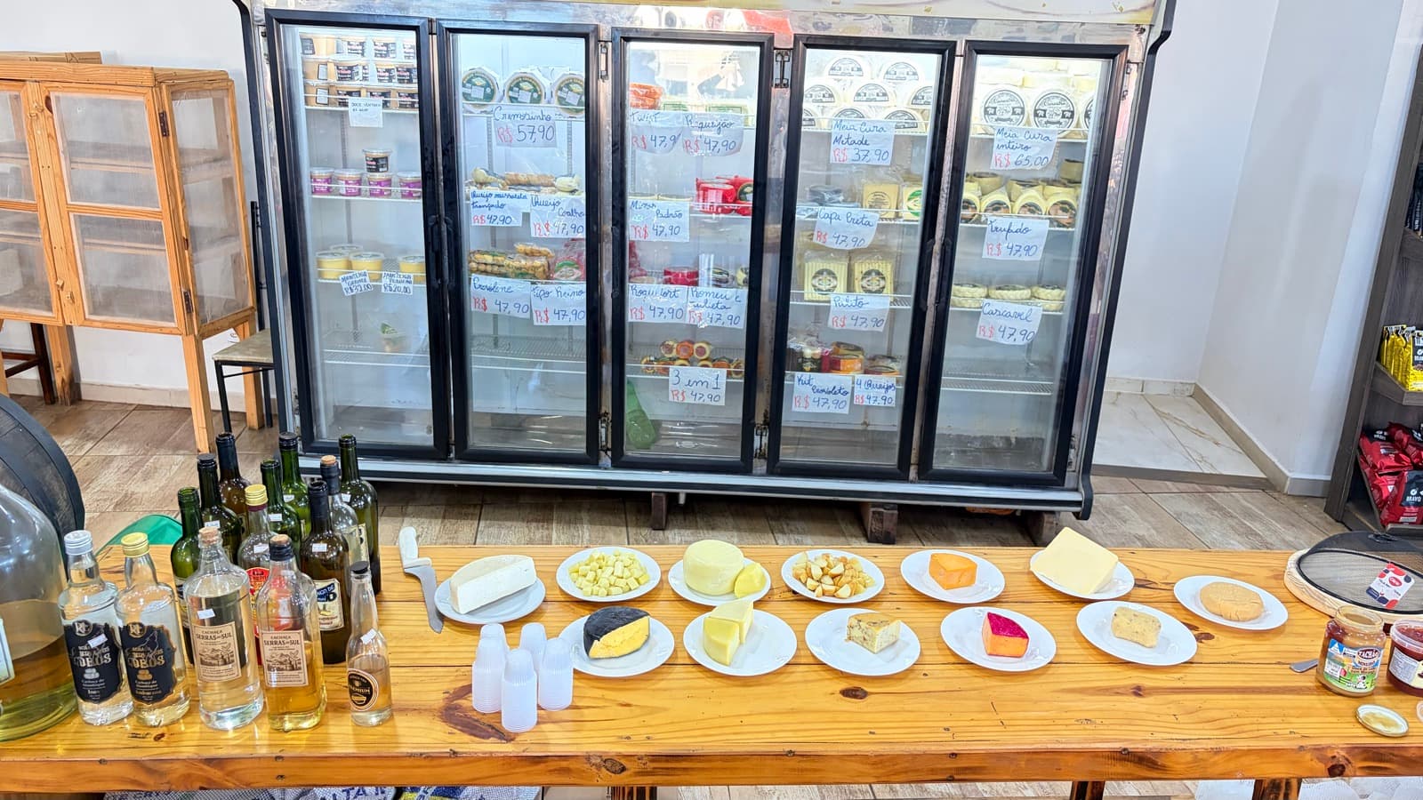 Mesa de degustação com queijos, cachaças e produtos mineiros no Prosa do Mineiro.