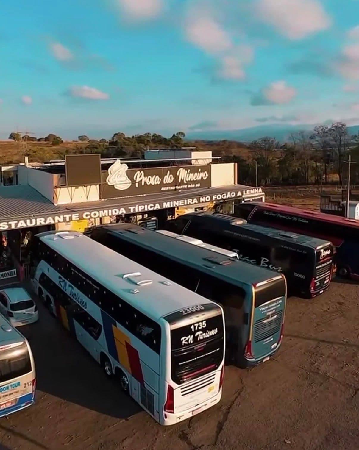 Vista aérea do estacionamento do Prosa do Mineiro com vários ônibus de excursão.
